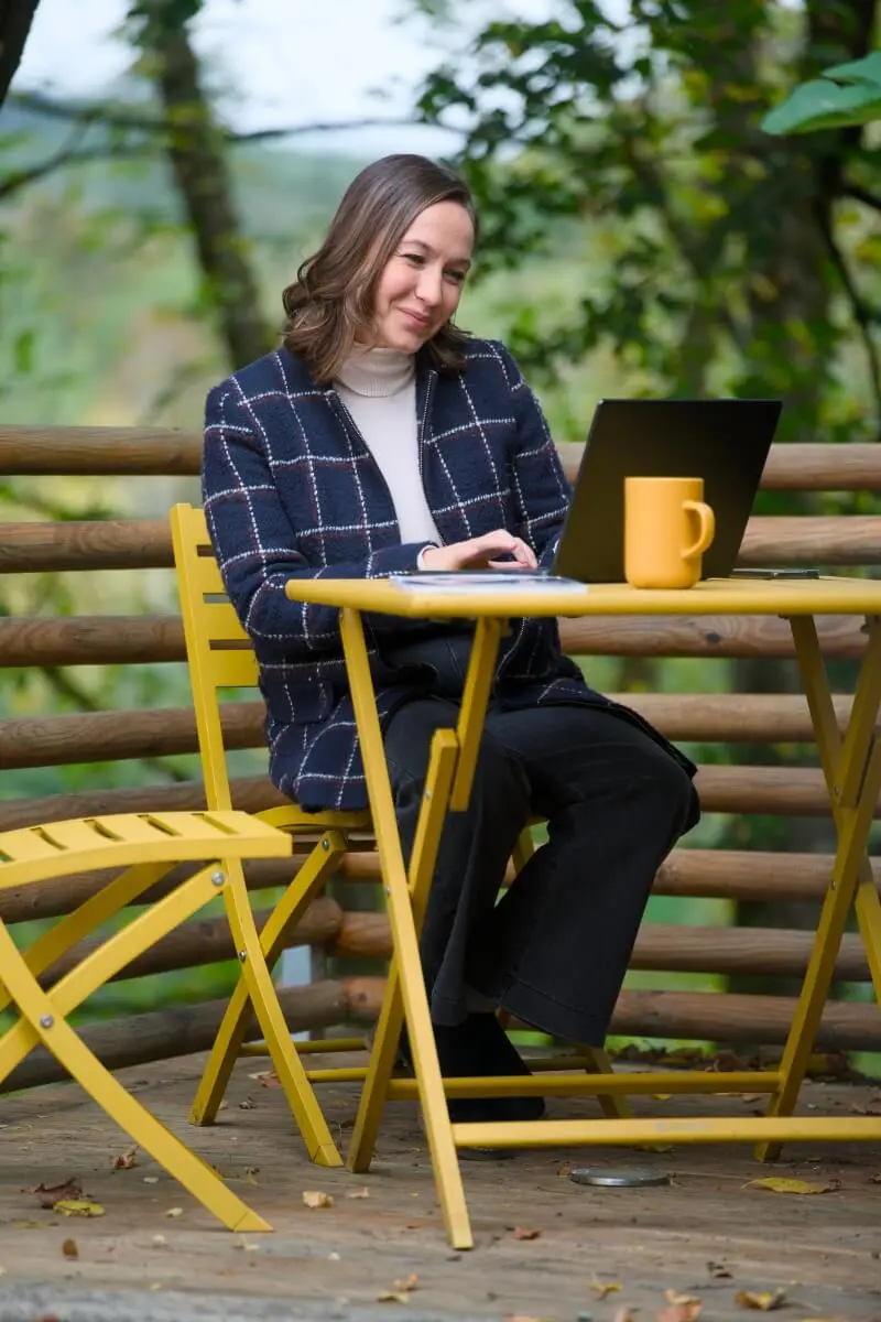 Personne travaillant sur un ordinateur portable dehors.