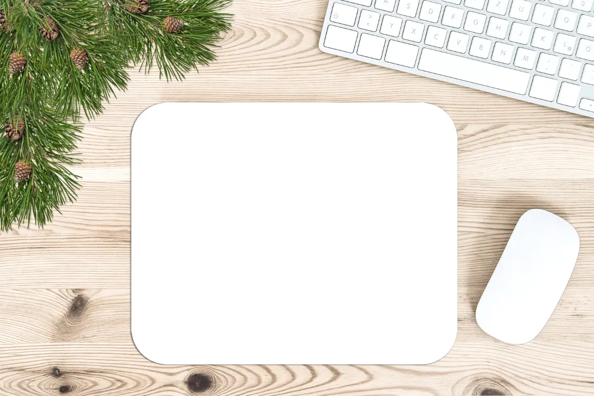 Clavier, souris et sapin sur bureau en bois.